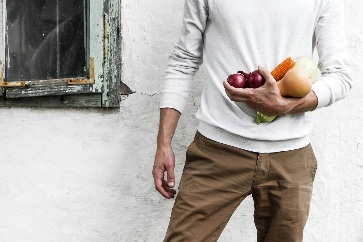 foods that boost testosterone including oysters, eggs, spinach, and avocados arranged on a wooden table
